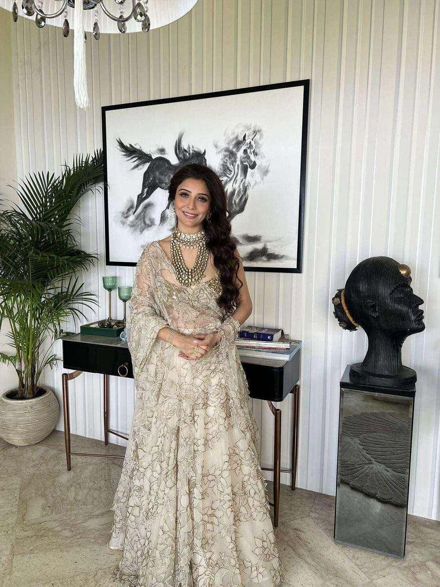 An ivory lehenga hanging in a pale room