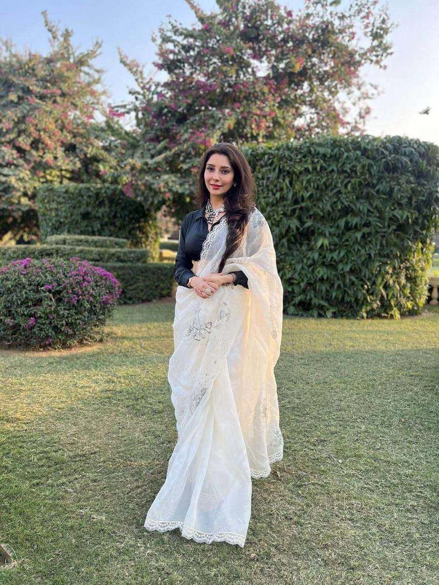 Dr. Jai Madaan, styled by Tanya Jain in a white embroidered saree on a garden lawn