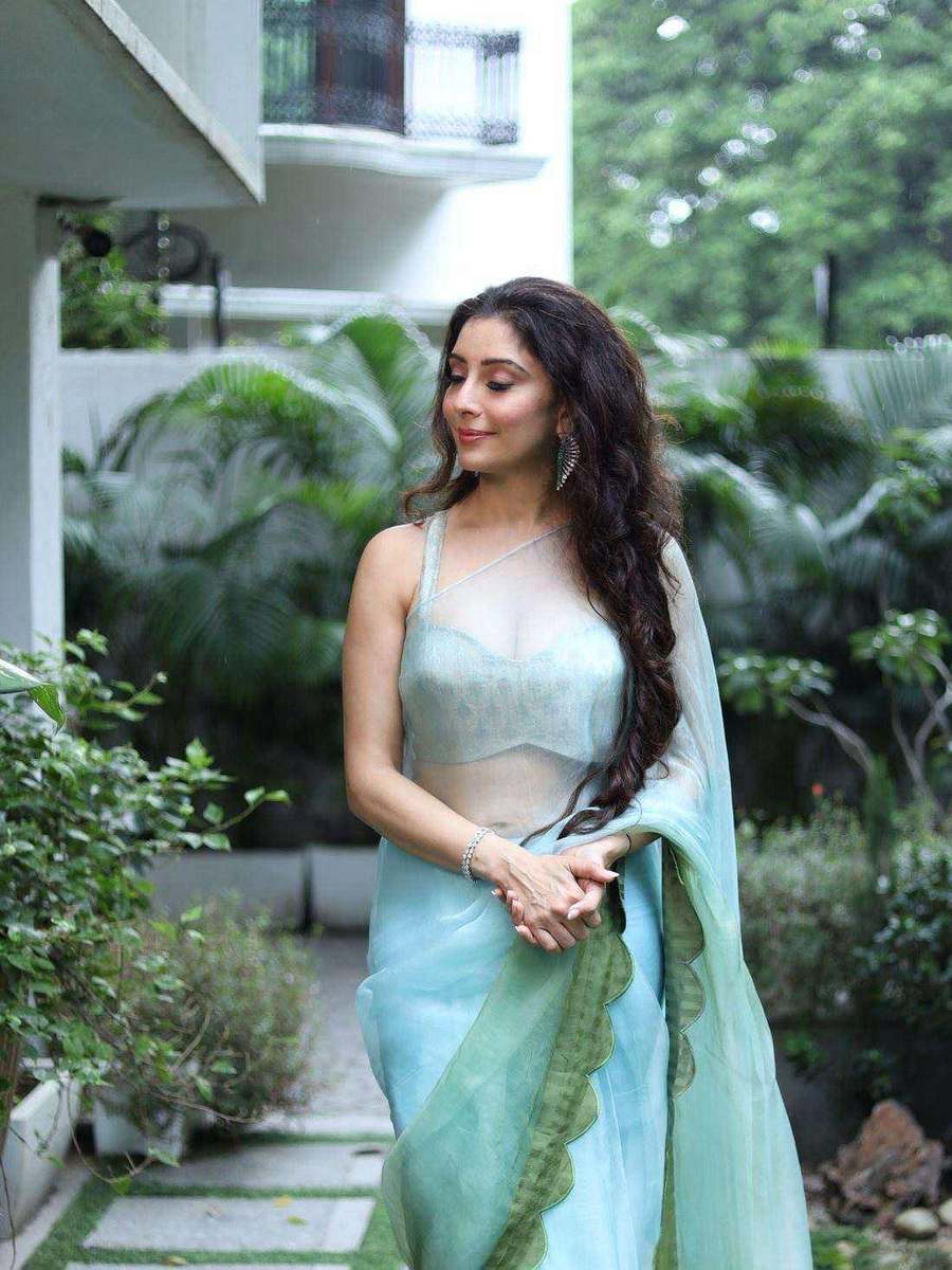 A client of Tanya Jain in a sage green drape, photographed in a garden