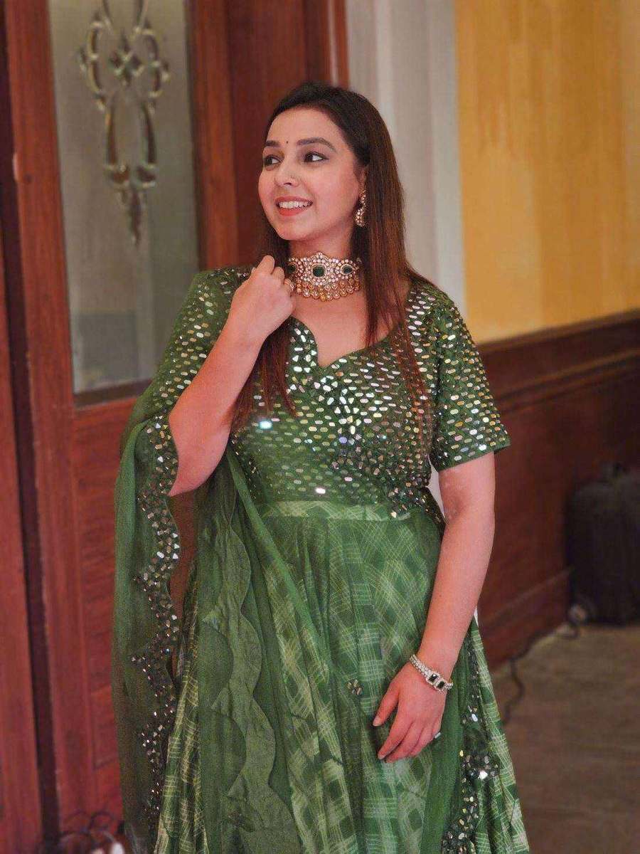 A styling client of Tanya Jain in a green mirror-work lehenga, photographed indoors