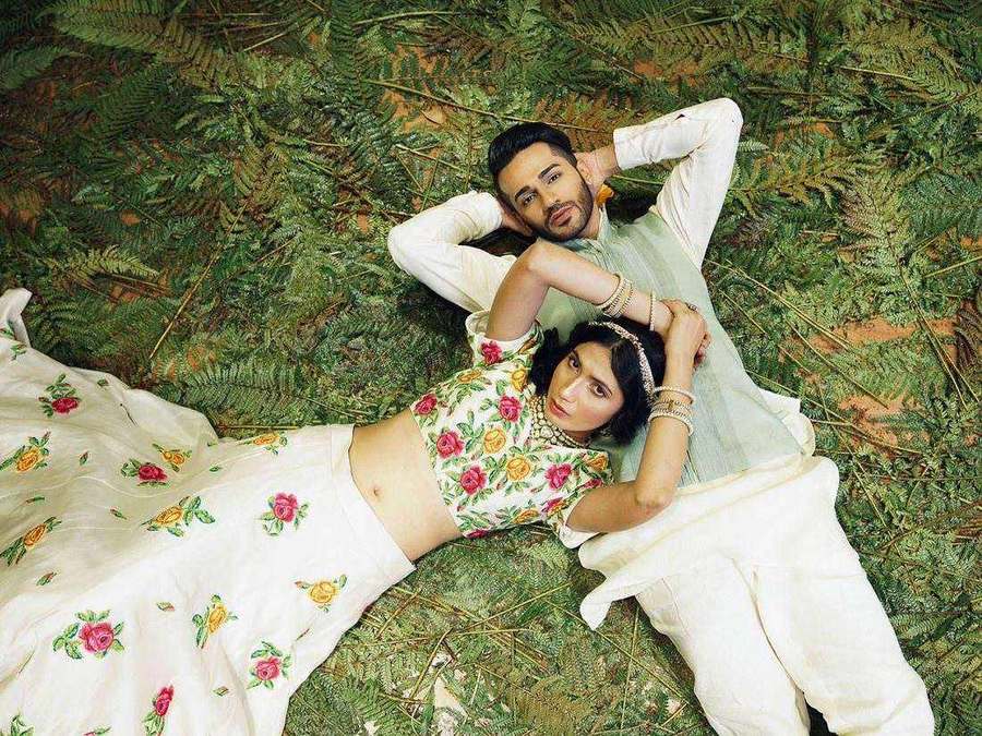 Two influencers styled by Tanya Jain lying on grass in ivory floral outfits