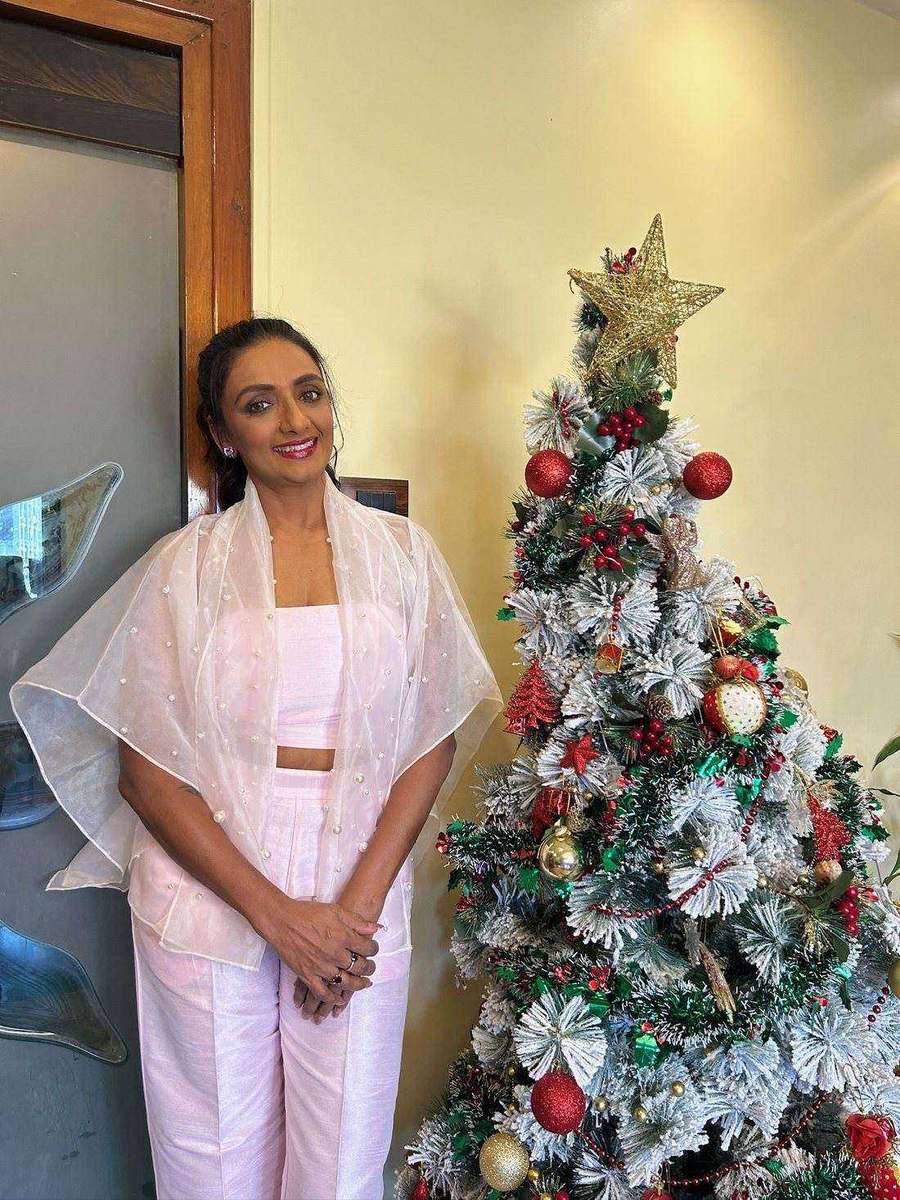 Shanthi Priya, styled by Tanya Jain in the same look, standing beside the tree